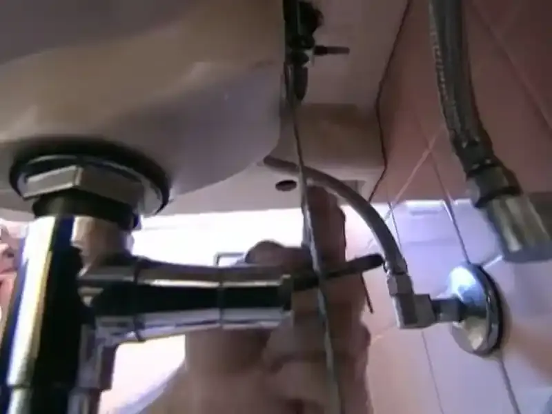 Chrome supply lines and drain fittings under a sink